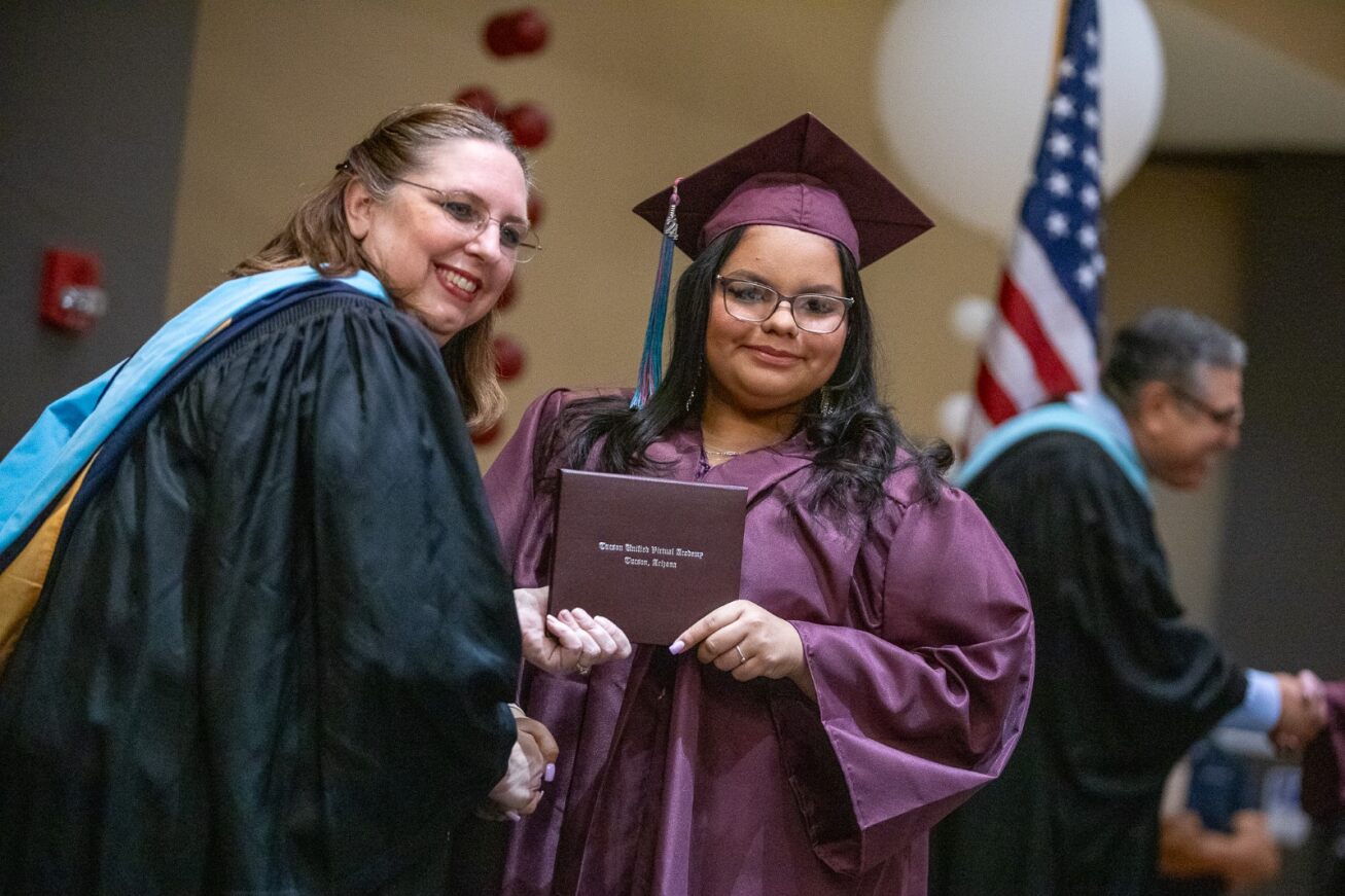 A TUVA grad receives her diploma from the principal