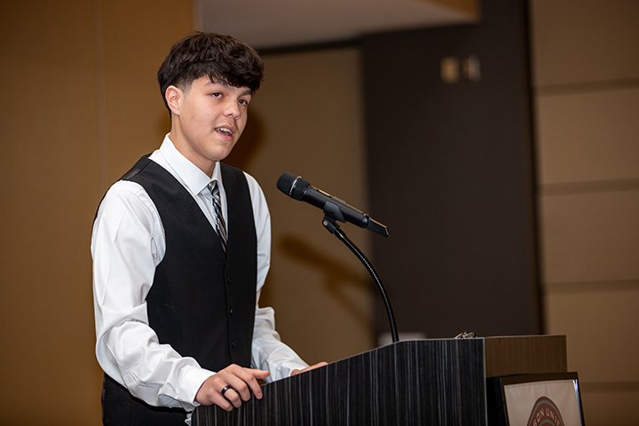 A teen boy addresses his fellow 8th graders