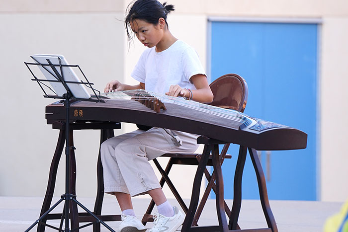 A girl plays a stringed instrument
