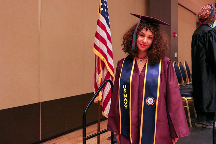 A graduate smiles as she walks off stage