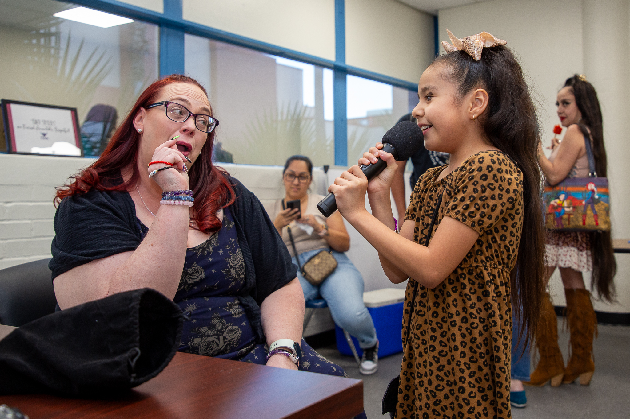 A girl sings into a mic during the karaoke portion of the event