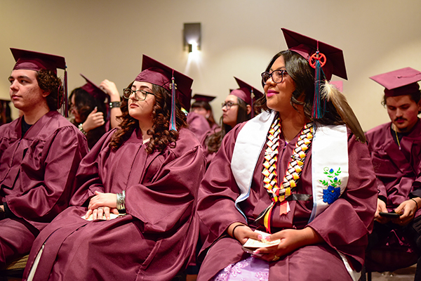 Graduates smile as they watch the ceremony
