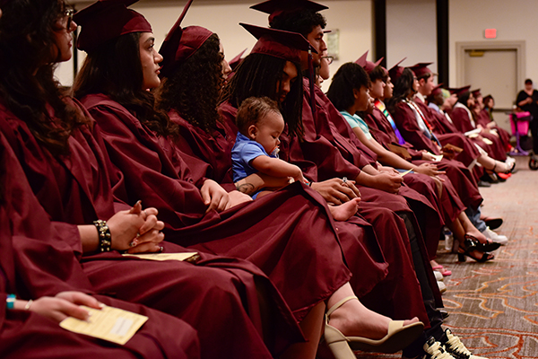 A line of graduates sitting and watching the ceremony